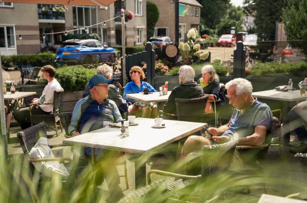 Vaste gasten aan tafel op het terras